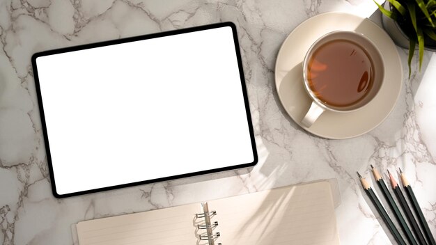 Minimal marble office desk with tablet empty screen mockup teacup and stationery top view