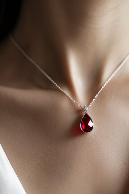 a minimal Martisor with a single sparkling red crystal suspended on a pure white thread