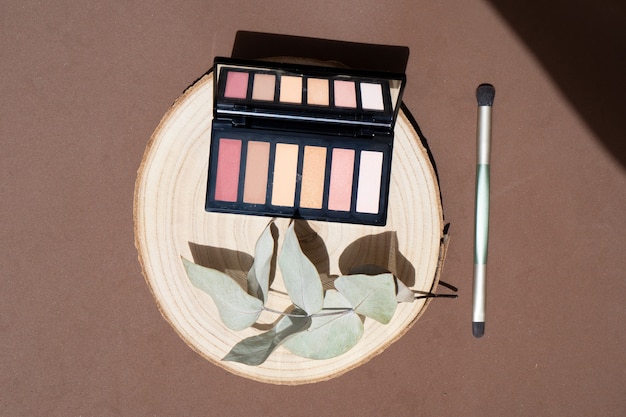 Photo minimal modern cosmetic scene with make up brushe, eye shadows and eucaliptus leaves