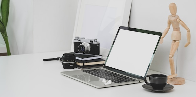 Minimal photographer workplace with open blank screen laptop 