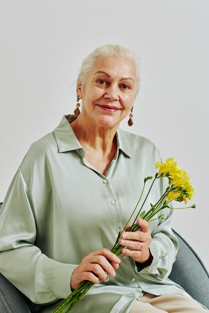 花を持つ年配の女性の最小限の肖像画
