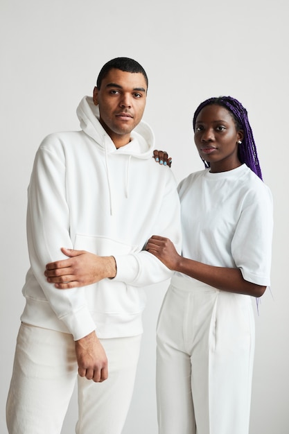 Photo minimal portrait of young mixed race couple wearing white while posing to camera