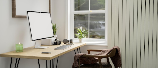 Minimal white home workplace with computer on wood table against the white wall