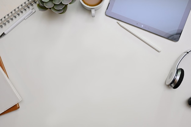 Minimal white office desk workspace top view with copy space\
and surrounded with office supplies