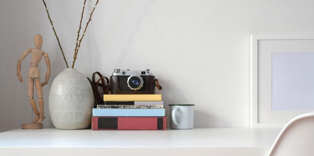 Minimal workplace style with office supplies and decorations on white desk and white wall 