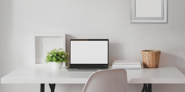 Minimal workspace with open blank screen laptop computer with mock up frame 