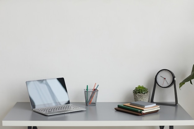 Minimale achtergrondafbeelding van thuiskantoor werkplek met laptop op bureau, kopieer ruimte