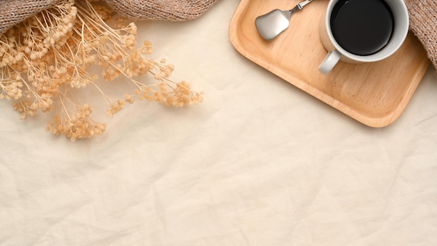 Minimale beige achtergrond met kopieerruimte voor tekstweergave, gedroogde bloemen en koffieset bovenaanzicht