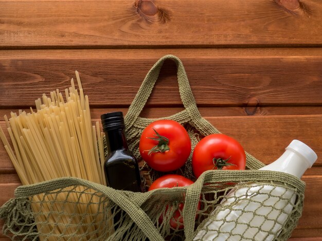 Minimale set producten in katoenen netzak. Pasta, olie, melk, tomaat. Verhoging van de productprijzen