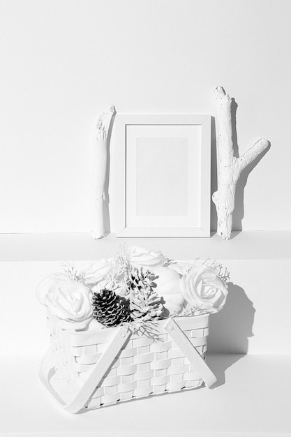 Minimale wintersamenstelling. Mand met witte kegels, rozen en pompoen. Frame mock-up ontwerp. Stilleven kunst
