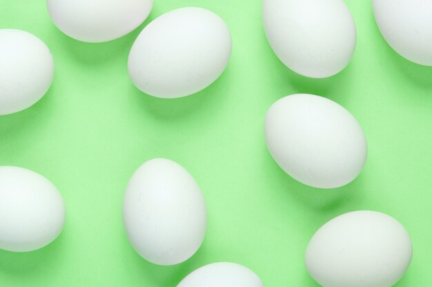 Photo minimalism food concept. a lot of eggs on green background. top view