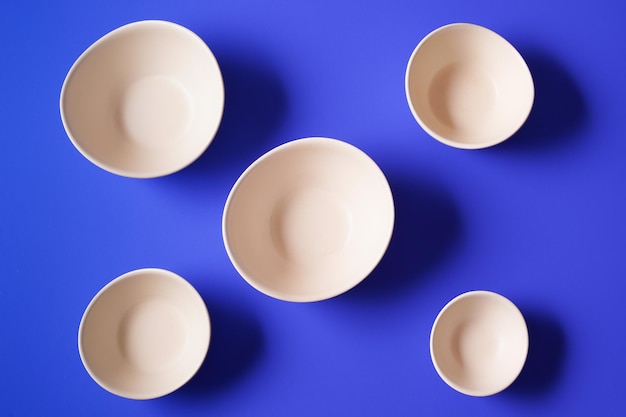 Minimalism style. Empty plates on blue paper background.