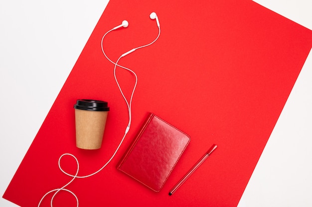 Minimalisme concept. papieren beker en notebook met pen op rood met kopie ruimte