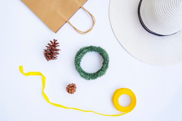 Minimalist Autumn Concept. Paper Bag, White Hat, Ribbon Rope, Pine Flowers, Krans Wreath Isolated On White Paper Background. Minimalist Christmas Concept