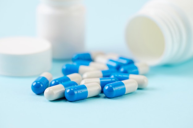 Minimalist blue and white pills with plastic bottle