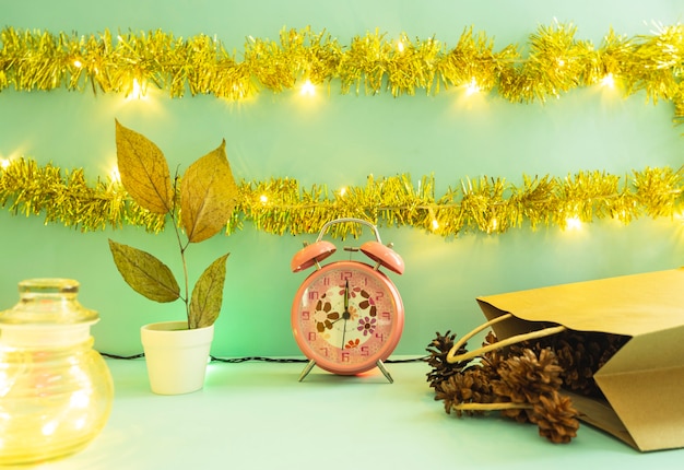 Minimalist concept idea displaying products. christmas and new\
year backgrounds. alarm clock. pine flower