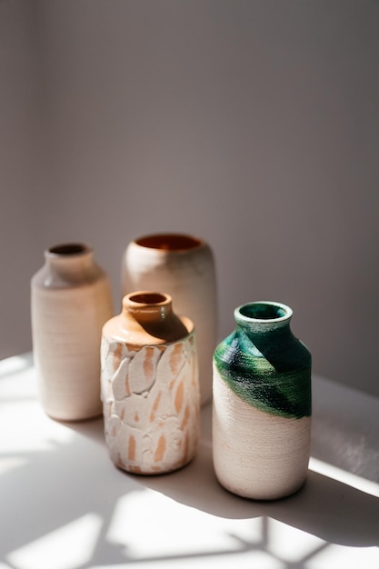 Minimalist handmade clay vases on a white background with daylight