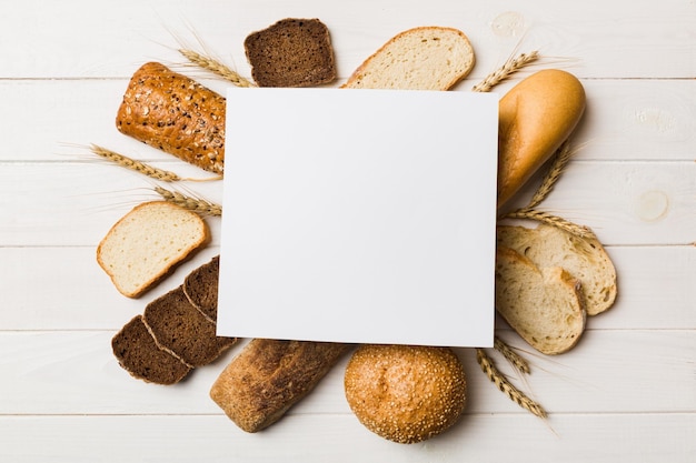 Minimalist paper blank mockup on background of Types of homemade bread Different kinds of fresh bread as background top view with space for your text or design