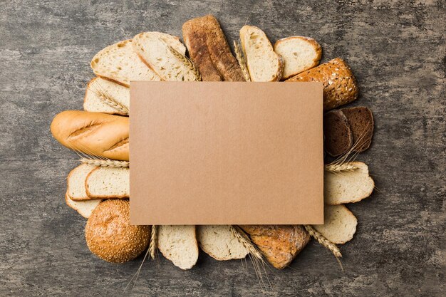 Minimalist paper blank mockup on background of Types of homemade bread Different kinds of fresh bread as background top view with space for your text or design