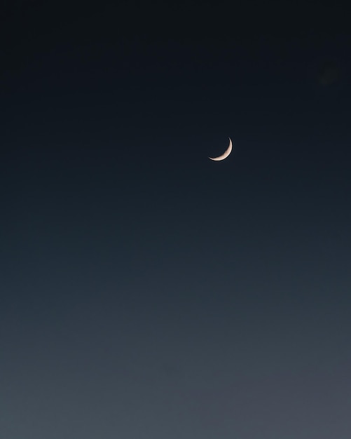 Minimalist picture of half moon in the sky isolated on the dark background