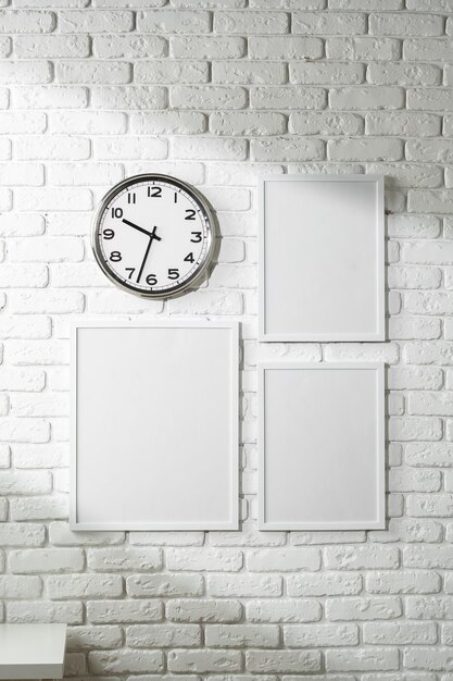 Photo minimalist white wall decor featuring a clock and blank photo frames