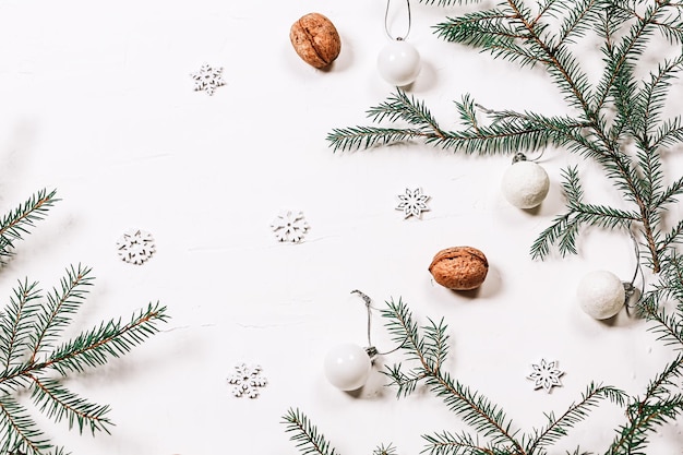 최소한의 크리스마스 배경 가문비나무 가지 호두와 흰색 배경에 눈송이