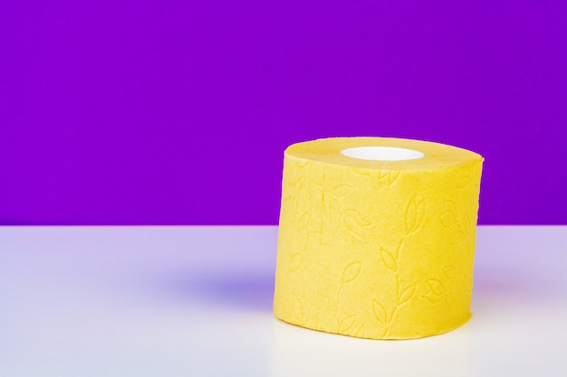 Minimalistic composition of bright yellow toilet paper rolls on purple