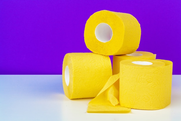 Minimalistic composition of bright yellow toilet paper rolls