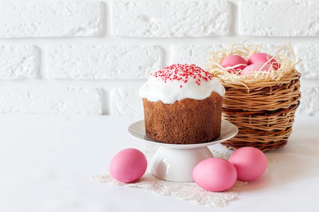 Composizione in pasqua minimalista con cesto di vimini e torta pasquale