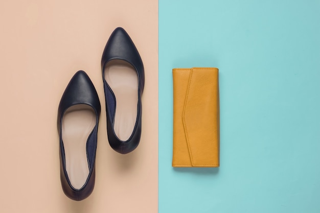 Minimalistic fashion still life. Classic womenÃÂÃÂ¢ÃÂÃÂÃÂÃÂs high heel shoes, yellow leather wallet on pink blue pastel background.