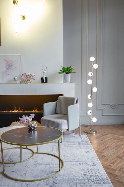 Minimalistic interior of an ultra modern open plan apartment with white and gray walls with a relief and gray stylish upholstered furniture and huge windows