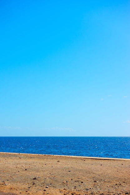 Minimalistic landscape with sea, coast and serene blue sky