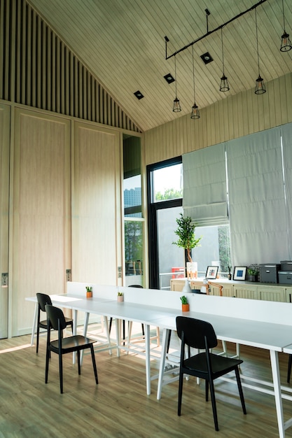 Minimalistic modern interior of a bright room. Table and chairs near the large window. Samui , Tailand - 02.08.2020