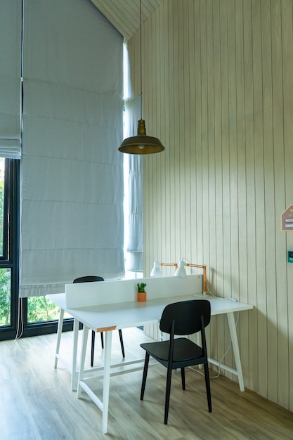 Minimalistic modern interior of a bright room. Table and chairs near the large window.