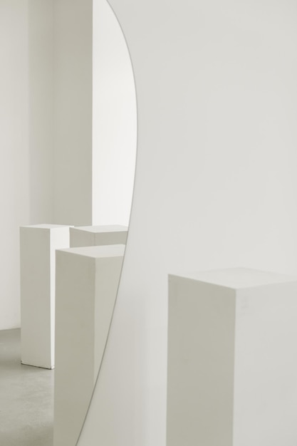 Minimalistic sculptor's workshop with pedestals for clay products and with a mirror