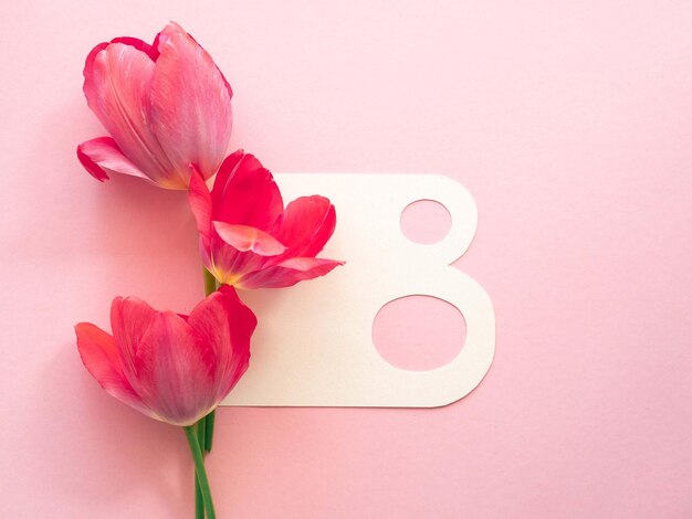 Photo minimalistic spring greeting card for women's day the number eight and pink tulips with