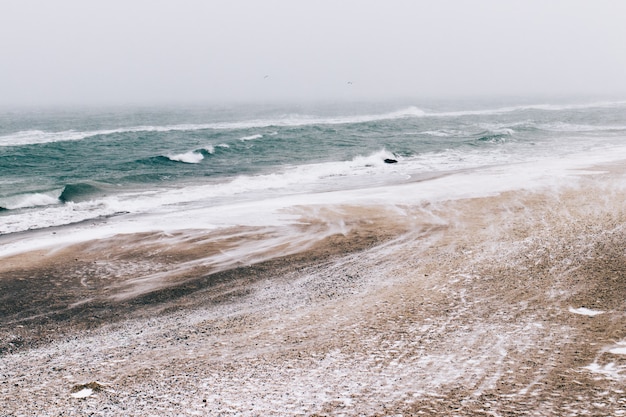 Minimalistic winter landscape, sea view during the snowfall