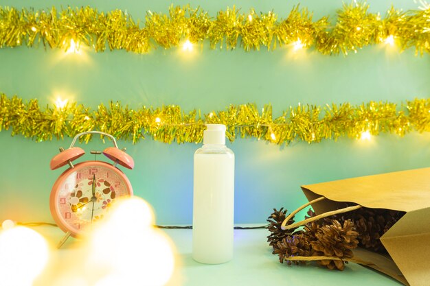 Minimalistisch conceptidee dat producten weergeeft. cosmetische flessen op Kerstmis en Nieuwjaar achtergrond. wekker. pijnboom bloem