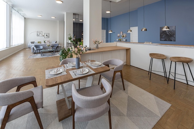 Minimalistisch modern interieurontwerp enorm licht appartement met een open plan in Scandinavische stijl in witblauwe en donkerblauwe kleuren met kolommen in het midden inclusief keuken, kantoor en woonkamer