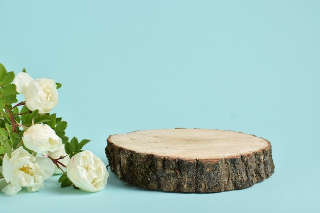 Minimalistisch podium met een houten podium op een lichtblauwe achtergrond met bloemen Podium voor de presentatie van producten en cosmetica Een vitrine met een podium voor natuurlijke producten