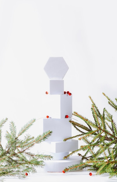 Minimalistische eco-vriendelijke Scandinavische kerstachtergrond in witte kleuren Spar-takken en wit leeg podium