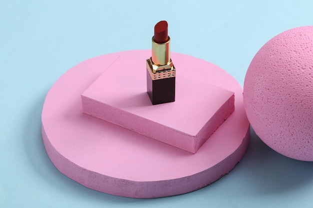 Minimalistische schoonheidsscène of showcase met lippenstift en roze platforms op blauwe achtergrond