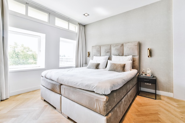 Minimalistische stijl interieur van slaapkamer met zacht bed en kussens in modern appartement