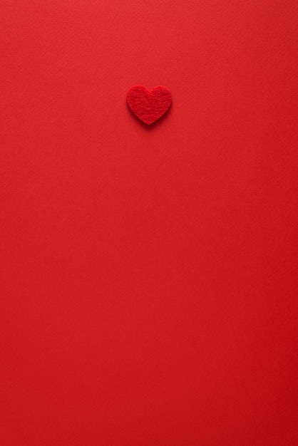 Minimalistische Valentijnsdag achtergrond met hart in rode kleur. Plat leggen met kopieerruimte