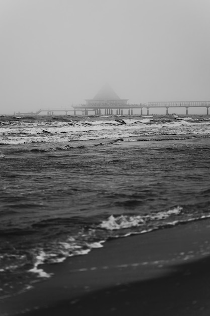 Minimalistische zwart-wit foto van de oceaan en een pier