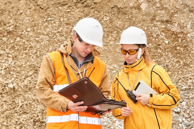 Mining engineers discussing working documentation outdoor at the mining site