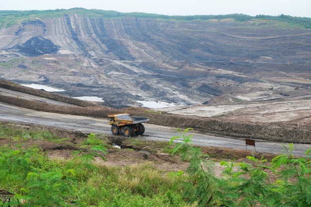 Photo mining truck in an open pit at coal mining or quarry