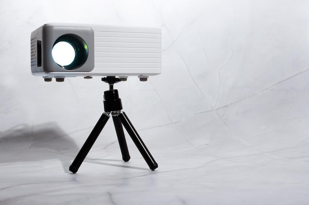 Miniprojector voor thuis op statief op lichte achtergrond