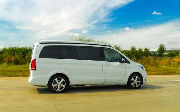 Minivans Car in road. Mini vans Auto vehicles on driveway. European transport for logistics services utilities at transportation work on motorway or highway.