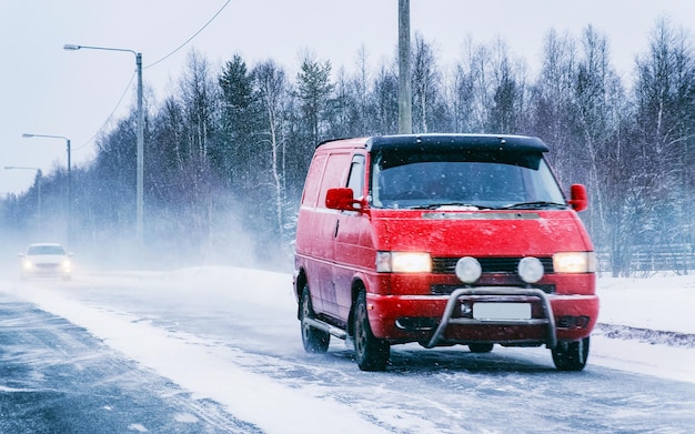 フィンランドの雪の冬の道路でミニバン車。私道のミニバン自動車。高速道路または高速道路の輸送作業におけるロジスティクスサービスユーティリティのためのヨーロッパの輸送。